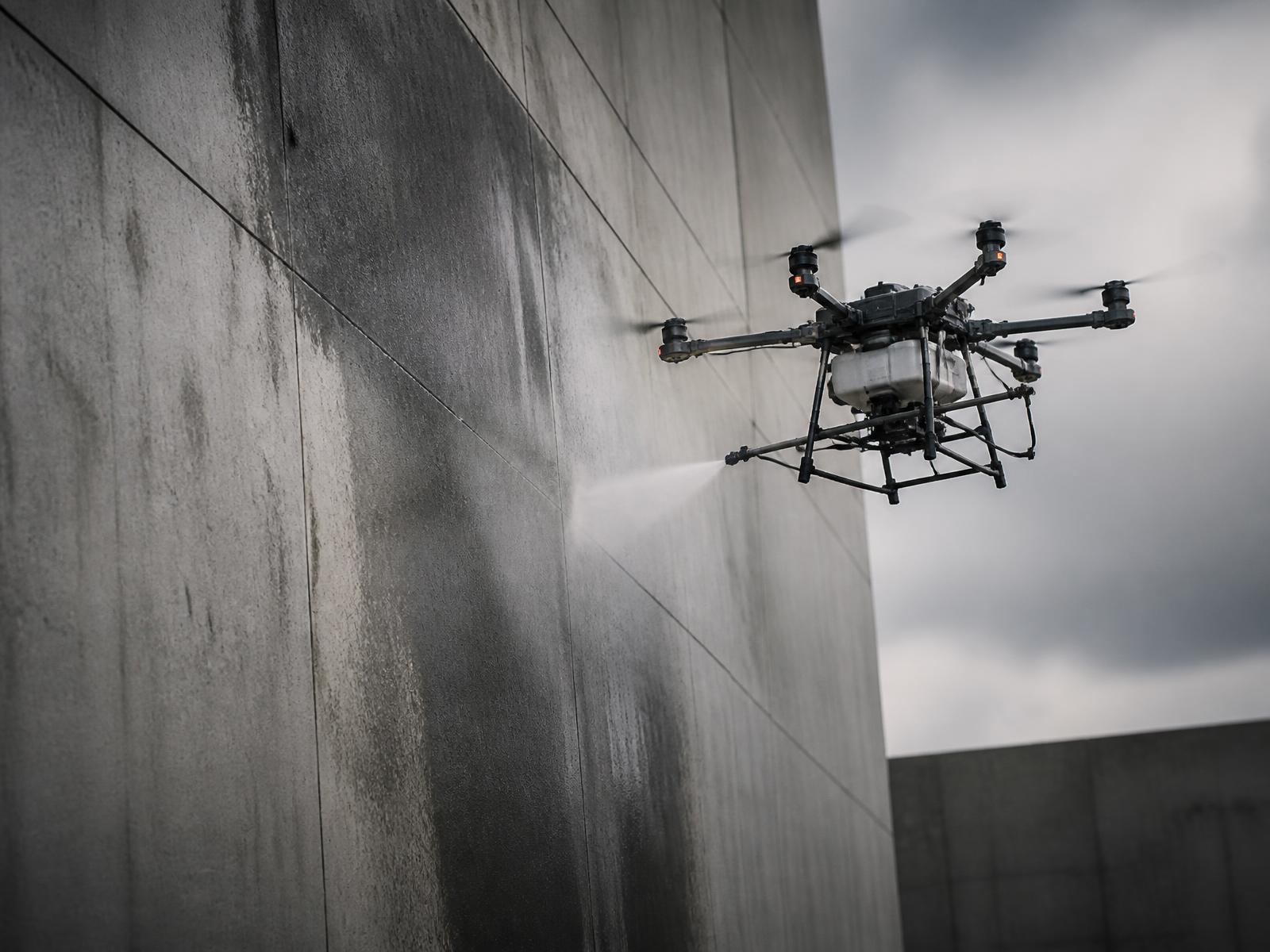 Dron nakładający środek chemiczny na betonową ścianę